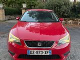 La voiture rouge est garée devant une maison.