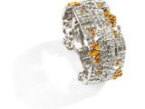 a close up of a ring with yellow and white diamonds