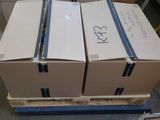 trois cartons posés sur une palette dans un entrepôt