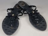 paire de sandales en cuir noir avec des lacets et des nœuds sur les orteils