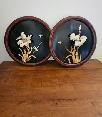 pair of black and white flowers in a wooden frame on a wooden table