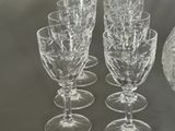 four wine glasses and a decanter on a table