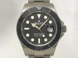 une montre au cadran noir montée sur un bracelet argenté