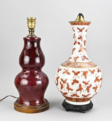 une paire de vases chinois posés sur des socles, surmontés d'une lampe