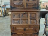 a wooden cabinet with drawers and a chair in a room