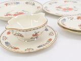 four pieces of porcelain dishes and cups on a white surface