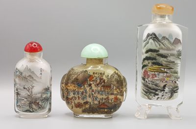 trois flacons à tabac en verre posés les uns à côté des autres sur une surface blanche