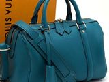 tiffany blue leather handbag next to a box of louis vuittois