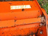 a small orange machine that is sitting in the grass