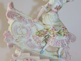 une figurine représentant une femme à cheval sur un cheval à bascule