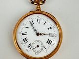 a gold pocket watch with roman numerals on it