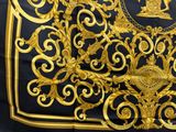 a black and gold scarf with a picture of a man on it