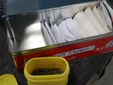 une boîte remplie de papiers, avec un récipient jaune à côté