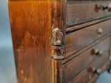 a small wooden chest of drawers on a table