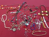 many different types of jewelry on a red table