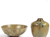 two vases sitting next to each other on a white surface