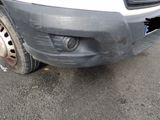 the front bumper of a white truck with a flat tire