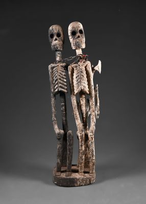 une sculpture en bois représentant deux squelettes debout l'un à côté de l'autre