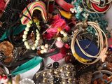 a pile of assorted jewelry on a white surface