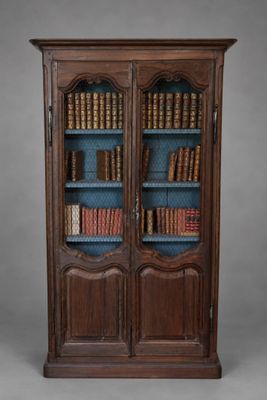 une bibliothèque en bois remplie de nombreux livres, posée sur une table