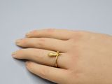 la main d'une femme portant une bague en or au doigt