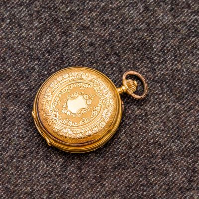 une montre de poche en or posée sur une table