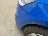 a close up of a blue car parked on the side of the road