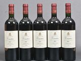 six bottles of wine are lined up in a row on a table