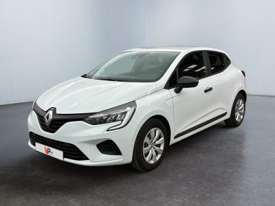 Une voiture blanche est garée dans une pièce au sol noir