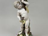 a figurine of a boy holding a bird on his head
