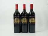 three bottles of red wine are lined up on a white surface
