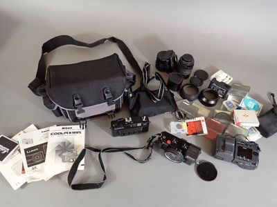 a camera, a camera case, a camera lens, and other items laid out on a table