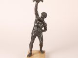 an image of a bronze statue of a man holding a hammer