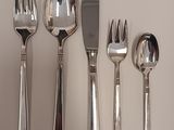 quatre fourchettes, deux cuillères et un couteau sur une table