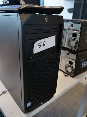 un ordinateur de bureau noir posé sur une table blanche