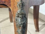 a close up of a wooden chair with a metal handle on it