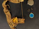 une image représentant un bracelet en or orné d'une pierre bleue et d'une chaîne en or