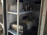 a refrigerator that has some pots and pans on it