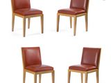 quatre chaises de salle à manger en cuir rouge avec des pieds en bois, sur fond blanc