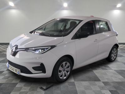 la voiture blanche est garée sur un sol en damier dans le garage