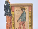toy figurine of a man in a cowboy hat and orange pants standing next to a box of tobacco