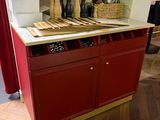 a red cabinet with a white counter top in a room