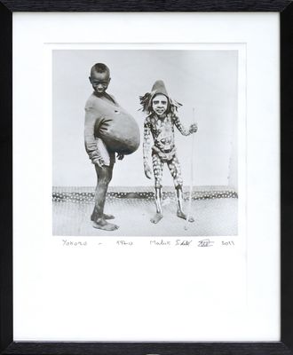 black and white photograph of two children playing with a ball