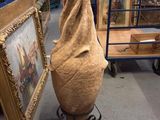 a large vase that is sitting on a stand in front of a picture