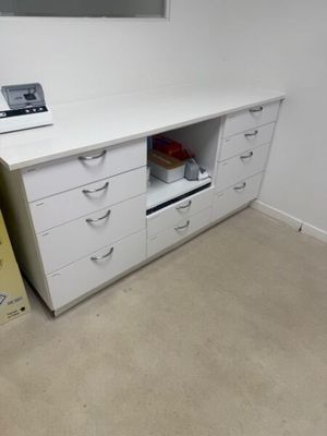 un bureau blanc avec des tiroirs, sur lequel est posé un ordinateur portable