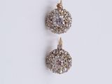 a pair of diamond earrings on a white background