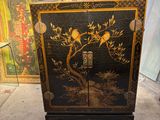 une armoire noire ornée d'un motif représentant un oiseau