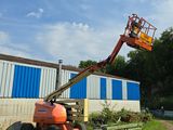 un homme sur une nacelle élévatrice, en train de travailler sur la façade d'un immeuble