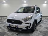 La Ford Kad blanche est garée dans une pièce au sol carrelé en damier.