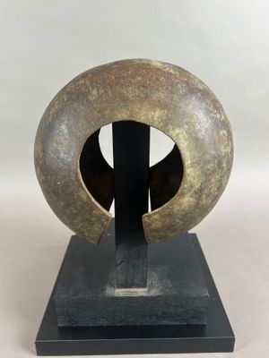 une photo d'une sculpture représentant un objet circulaire posé sur un socle